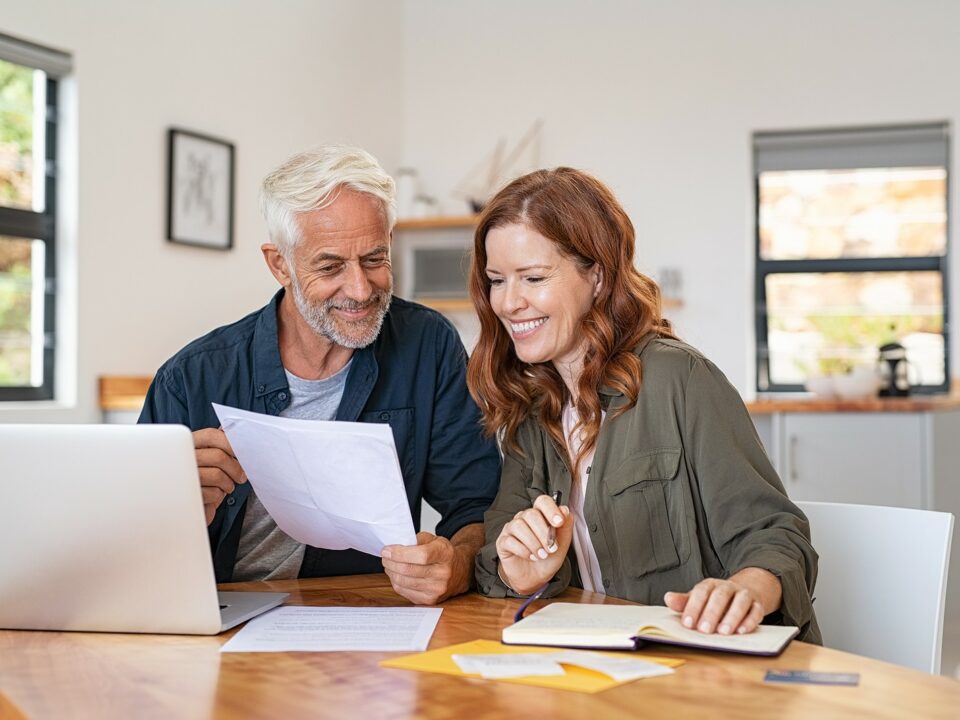 Senior couple reviews their finances at home.