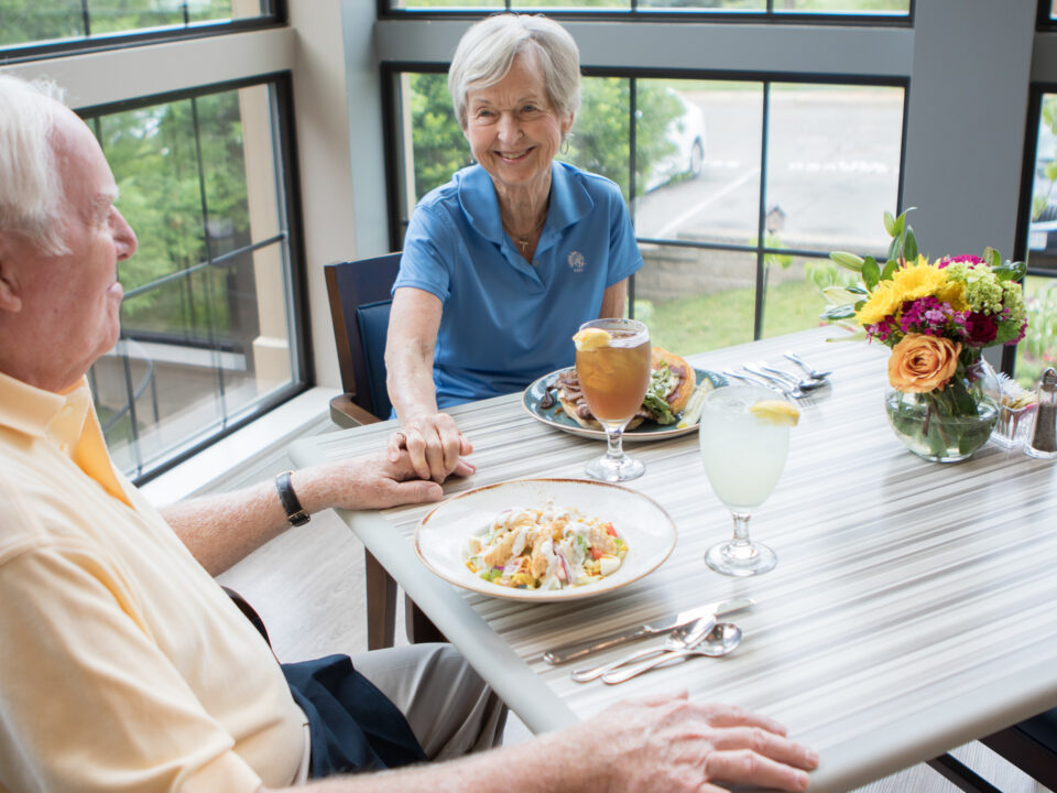 senior man and woman eating at table