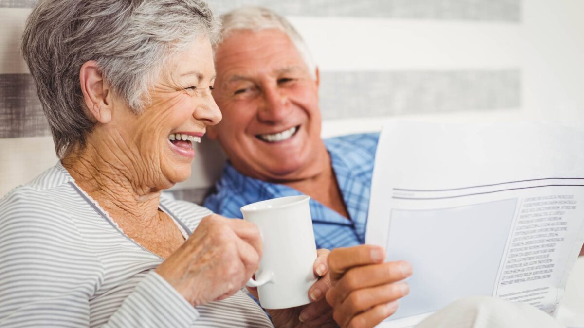 senior couple enjoying coffee while reading the newspaper