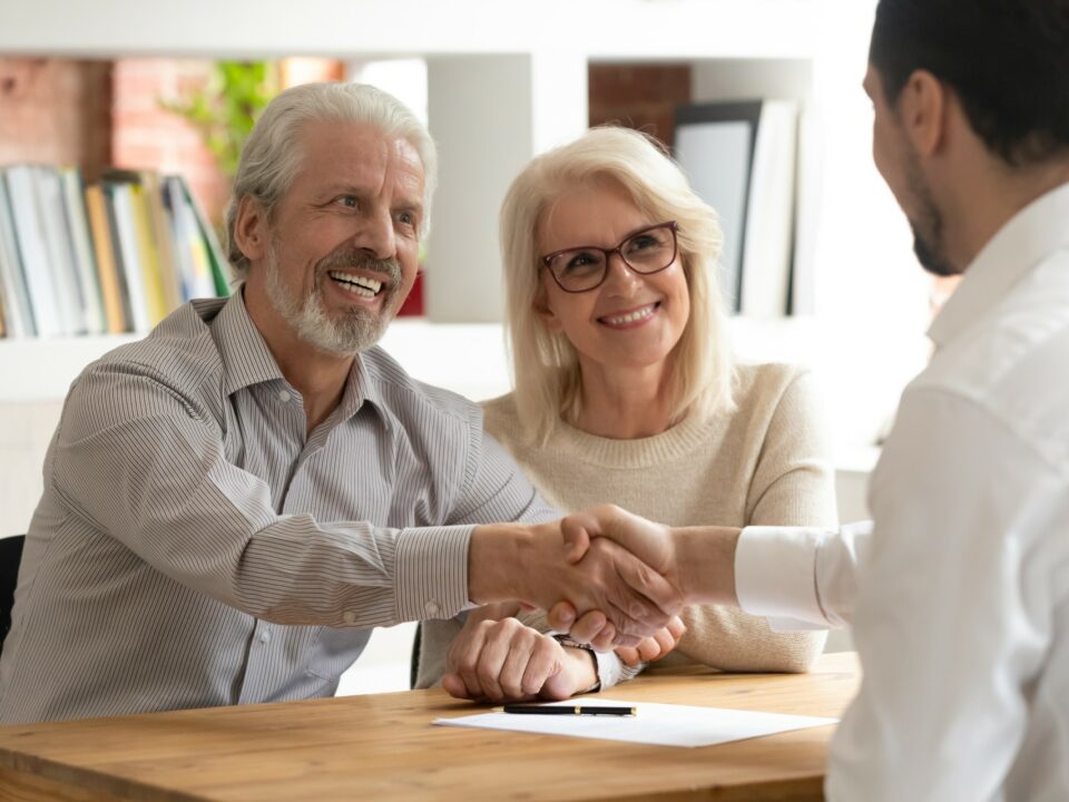 Senior couple shaking hands with a financial advisor