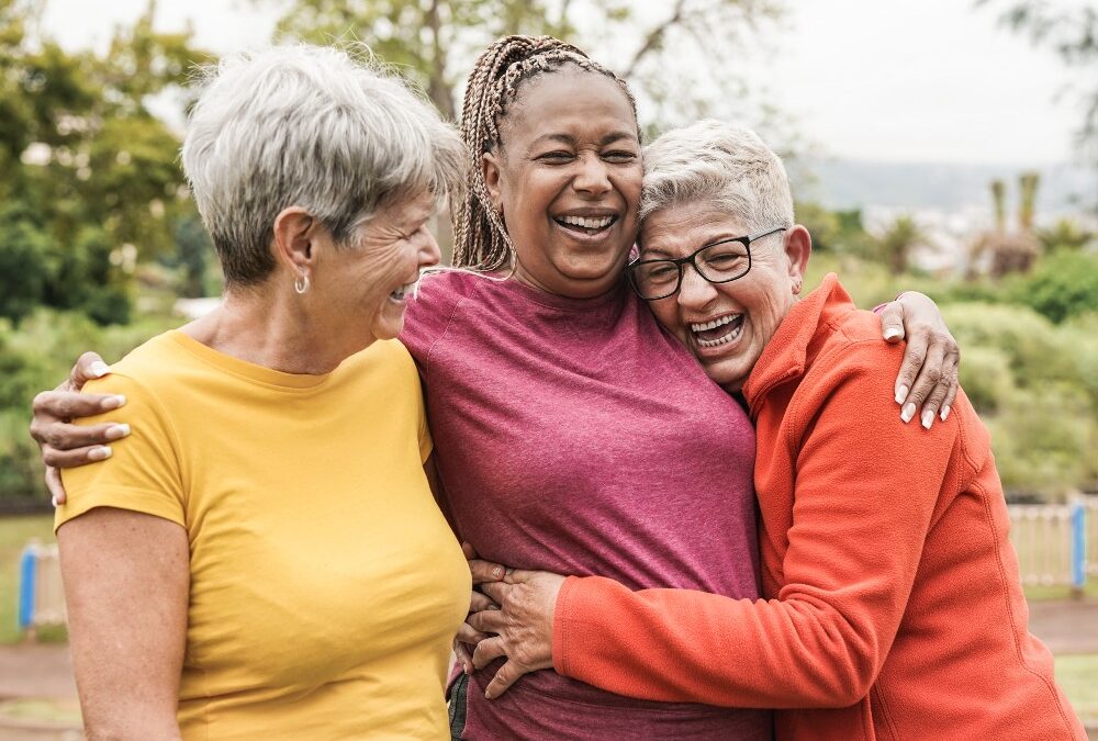 happy senior women hugging outside a senior living community