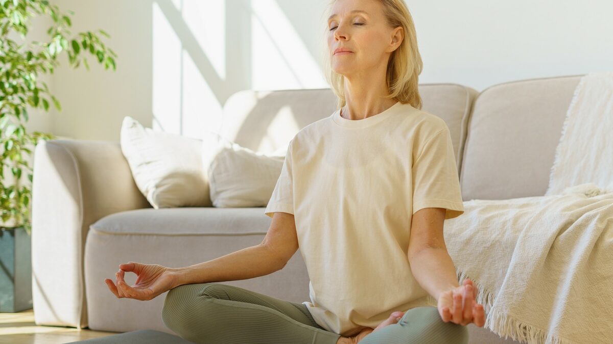 Senior woman doing lotus position and practicing wellness.